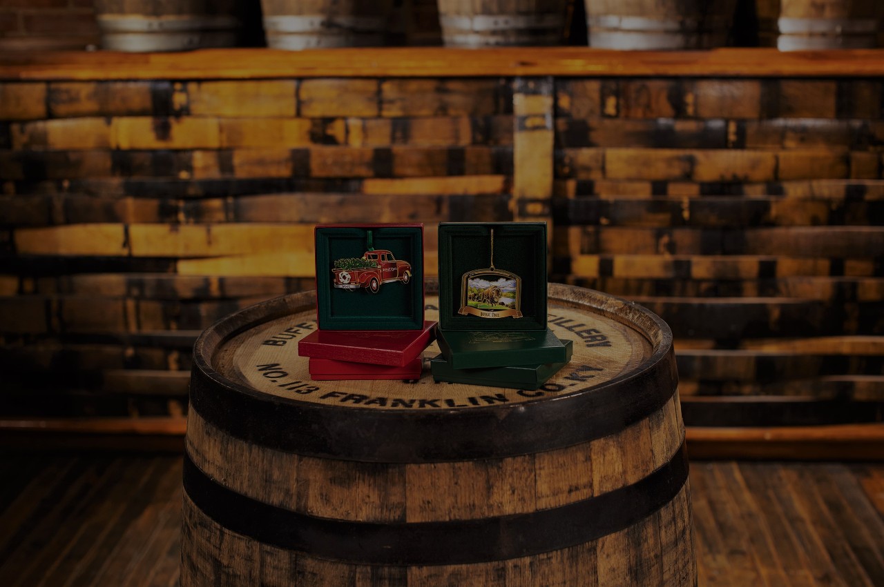 Assortment of Buffalo Trace Gift Shop Christmas Ornaments displayed on a barrel